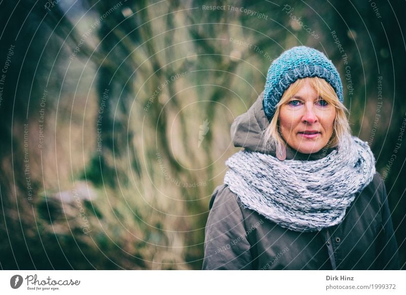 Woman with cap in cold season Human being Feminine Adults Life 1 45 - 60 years Jacket Blonde Uniqueness natural Blue Looking Observe Forest To go for a walk