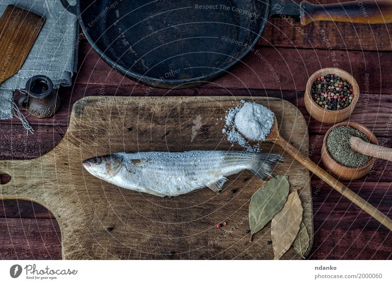 Frozen fish smelt on a kitchen cutting board Food Fish Herbs and spices Nutrition Eating Diet Pan Spoon Table Kitchen Wood Metal Fresh Above Brown Black pepper