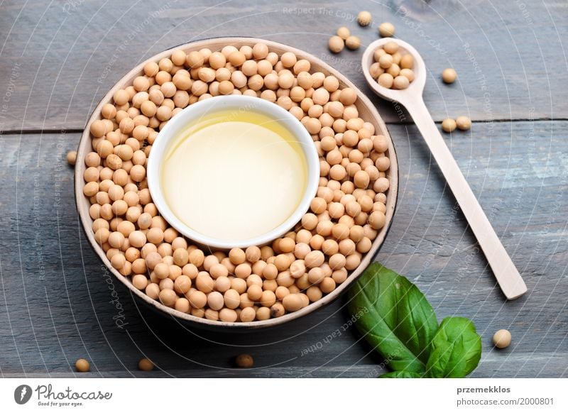 Soy beans and soy oil in bowls on wooden table Grain Nutrition Organic produce Vegetarian diet Asian Food Bowl Spoon Container Wood Fresh Healthy Natural Beans