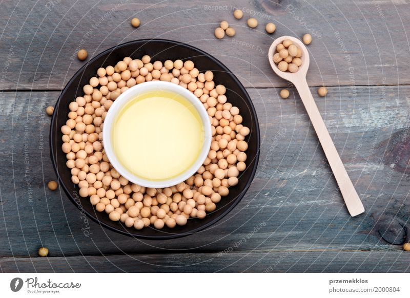 Soy beans and soy oil in bowls on wooden table Grain Nutrition Organic produce Vegetarian diet Bowl Spoon Wood Fresh Healthy Natural Beans Fiber food