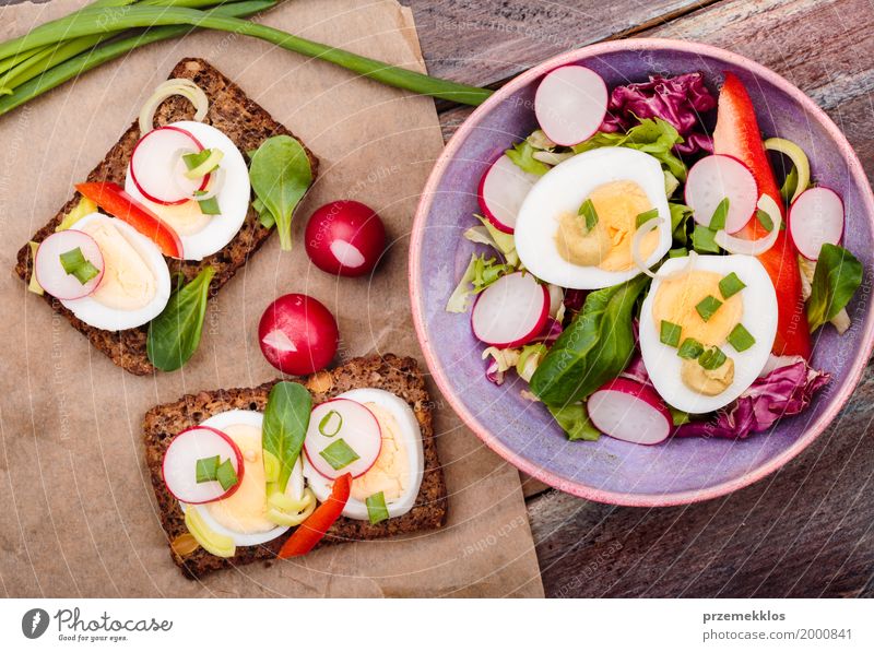 Healthy meal with eggs and vegetables Food Vegetable Lettuce Salad Bread Lunch Vegetarian diet Diet Bowl Table Wood Fresh Delicious Meal overhead Sandwich Sauce