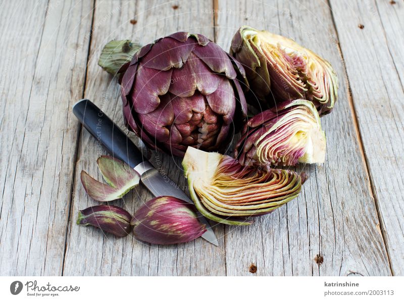 Roman Artichokes on a wooden board with knife Vegetable Nutrition Vegetarian diet Italian Food Knives Fresh Gray Green agriculture Purple cooking Cut Edible