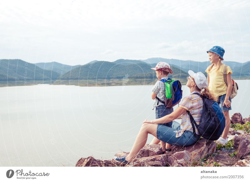 Happy family standing near the lake at the day time. Lifestyle Healthy Vacation & Travel Tourism Trip Freedom Summer Mountain Hiking Looking Sit Colour photo