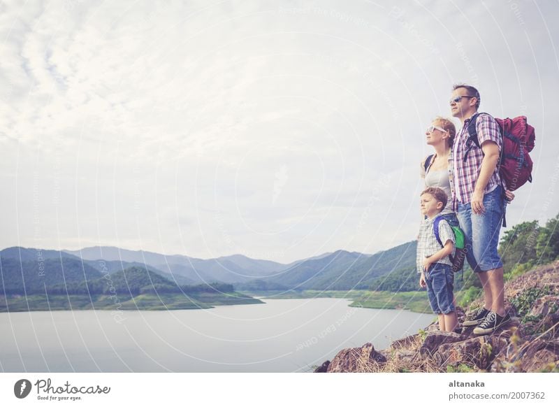 Happy family standing near the lake at the day time. Lifestyle Joy Leisure and hobbies Vacation & Travel Trip Adventure Freedom Camping Summer Mountain Hiking