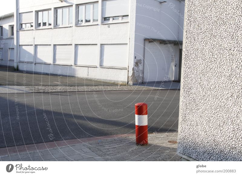 Urban Little Red Riding Hood Deserted Industrial plant Building Street Bollard Stand Loneliness White Structures and shapes Colour photo Exterior shot Day