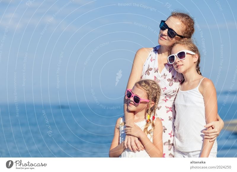 Mother and children playing on the beach at the day time. Concept of friendly family. Lifestyle Joy Relaxation Leisure and hobbies Playing Vacation & Travel