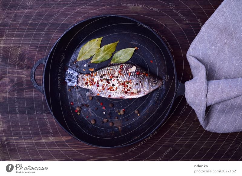 Crucian carp in spices on a black cast-iron frying pan Food Fish Herbs and spices Nutrition Pan Table Kitchen Nature Leaf Wood Diet Eating Fresh Natural Above