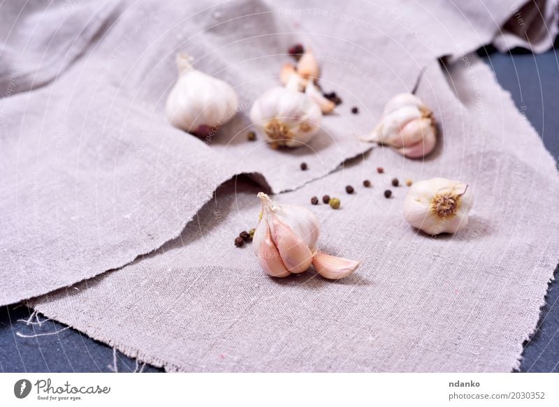 White garlic on a gray textile napkin Vegetable Herbs and spices Cloth Eating Fresh Natural Gray Fragrant Garlic cook seasoning Ingredients background food Raw