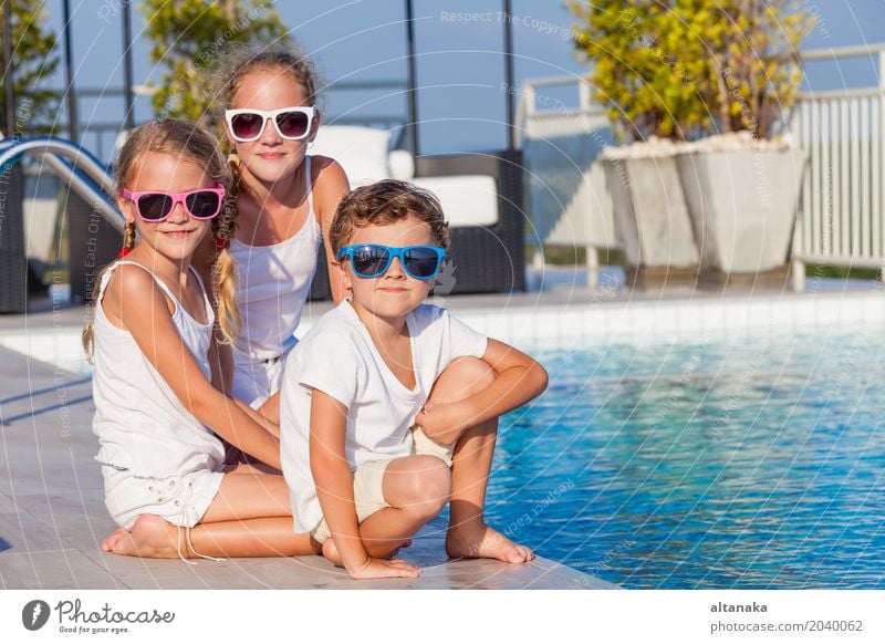happy children playing near the swimming pool Lifestyle Joy Happy Face Relaxation Swimming pool Leisure and hobbies Playing Vacation & Travel Summer Sun Sports
