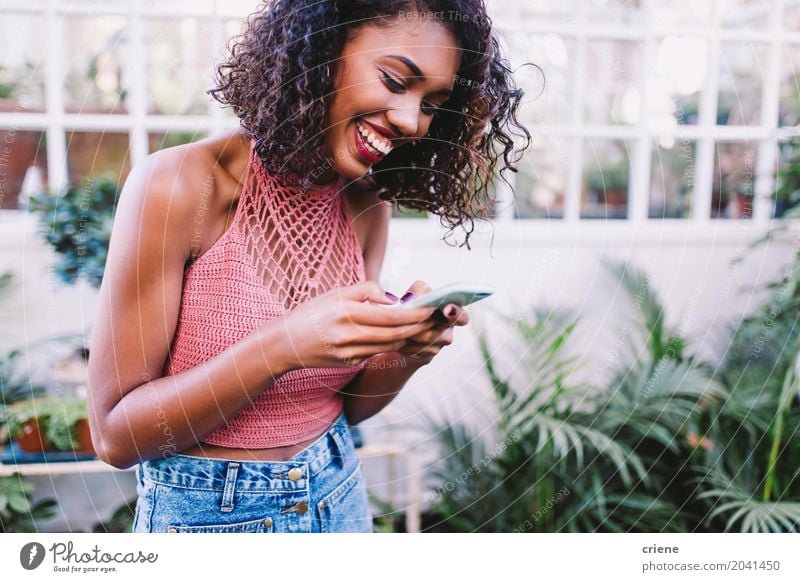 African American happy woman typing message on smartphone Lifestyle Joy Happy Summer Garden Entertainment Telephone Cellphone PDA Screen Technology