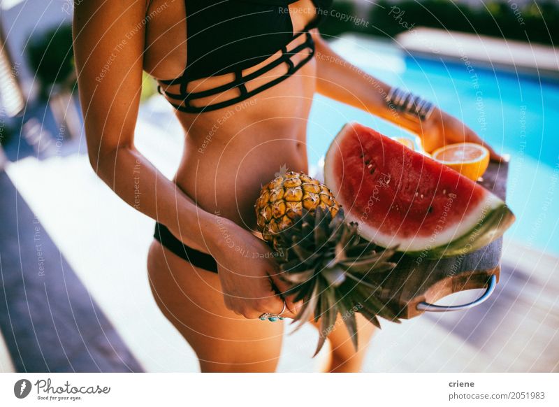 Young woman serving fresh fruits on wooden board Fruit Nutrition Eating Lifestyle Happy Swimming pool Vacation & Travel Summer Woman Adults Bikini Carrying