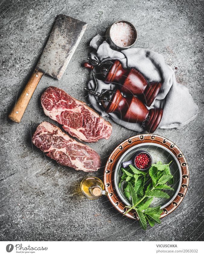 Marbled Ribeye steaks on the kitchen table Food Meat Herbs and spices Nutrition Lunch Dinner Organic produce Crockery Knives Style Design Table Kitchen