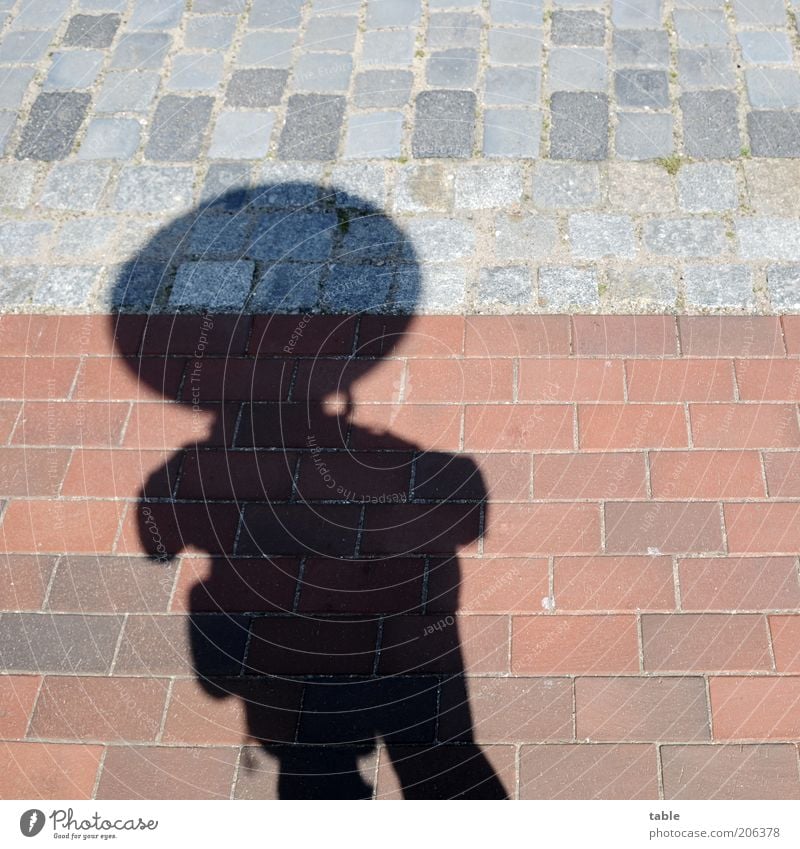 hombre emprendedor Human being Masculine Man Adults 1 Stone Brick Stand Wait Dark Large Gray Red Black Serene Shadow play Sidewalk Colour photo Exterior shot