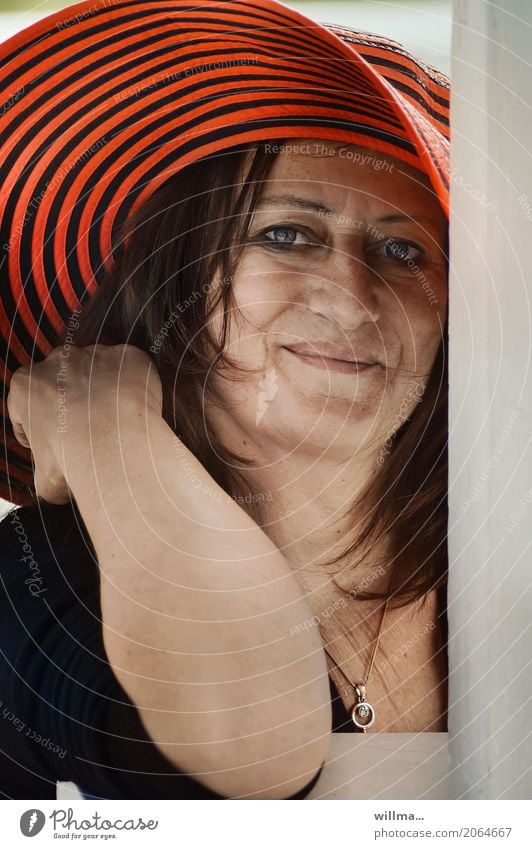 smiling mature woman with red hat Feminine Woman Adults Human being Necklace Hat Brunette Smiling Direct portrait Looking into the camera Attractive Striped