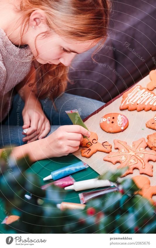 Girl decorating Christmas gingerbread cookies with chocolate Food Lifestyle Decoration Table Feasts & Celebrations Christmas & Advent Human being 13 - 18 years