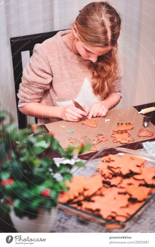 Girl decorating Christmas gingerbread cookies with chocolate Lifestyle Decoration Table Kitchen Feasts & Celebrations Christmas & Advent Human being 1