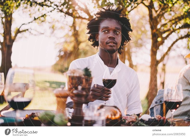 Afro American man enjoying wine at lunch party Food Lunch Dinner Beverage Drinking Alcoholic drinks Wine Summer Garden Table Human being Masculine Man Adults