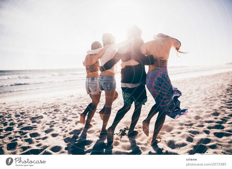 Happy group of young adult friends walking on the beach together Lifestyle Joy Leisure and hobbies Freedom Summer Summer vacation Beach Ocean Human being