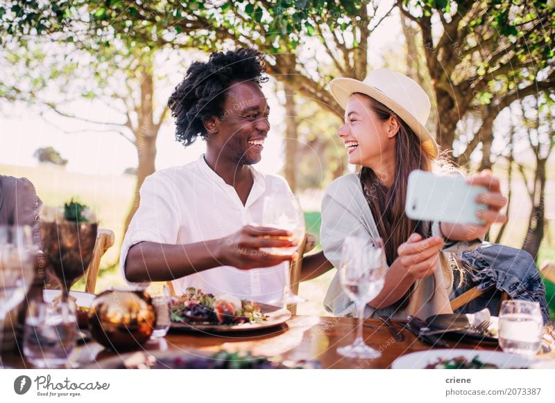 Cute young adult couple taking photo at outdoor picnic Eating Lunch Dinner Picnic Drinking Wine Plate Lifestyle Joy Summer Garden Party Restaurant Flirt