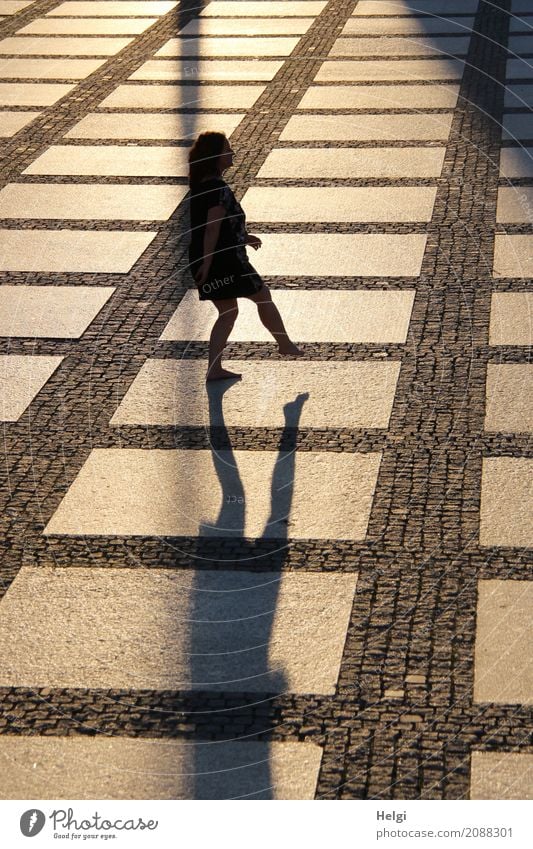 Silhouette of a woman standing on one leg on a large paved square in backlight with shadow Human being Feminine Woman Adults 1 45 - 60 years Chemnitz Places