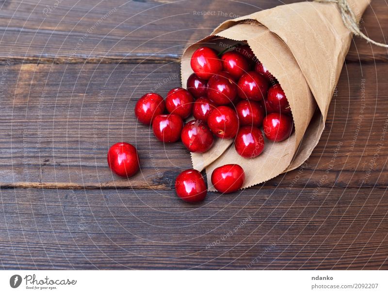 Red ripe cherry in a paper bag Fruit Dessert Eating Vegetarian diet Juice Summer Table Nature Paper Wood Fresh Natural Above Retro Juicy background Berries