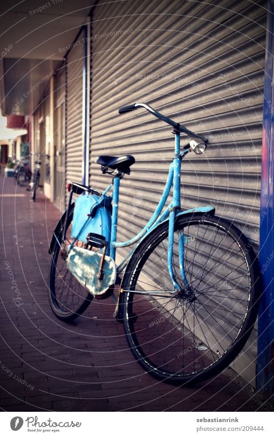 Dutch bicycle Bicycle Door Garage door Gate Transport Means of transport Stone Metal Old Dirty Dark Original Retro Gloomy Town Blue Colour photo Exterior shot