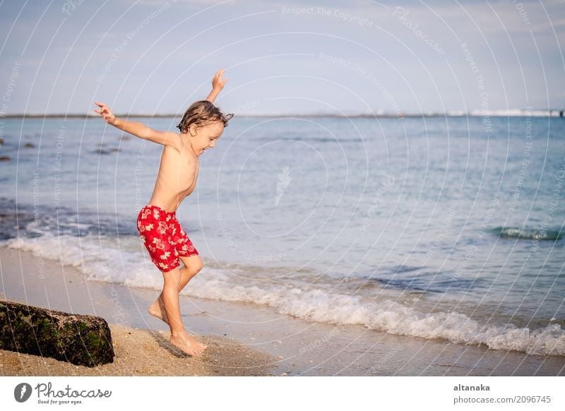 Happy little boy jumping on the beach Lifestyle Joy Relaxation Leisure and hobbies Playing Vacation & Travel Trip Adventure Freedom Summer Sun Beach Ocean Child
