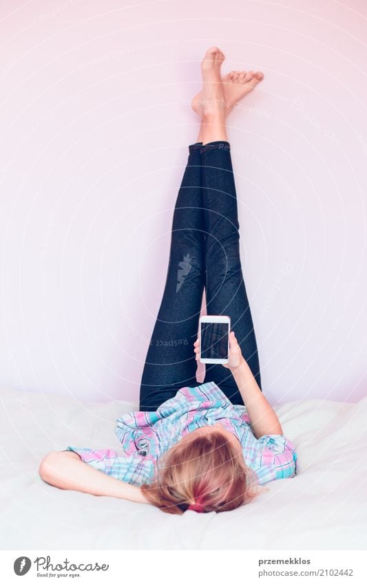 Young gril using mobile phone lying on bed Lifestyle Beautiful Playing Bedroom Child Telephone Cellphone Technology Human being Girl 1 13 - 18 years