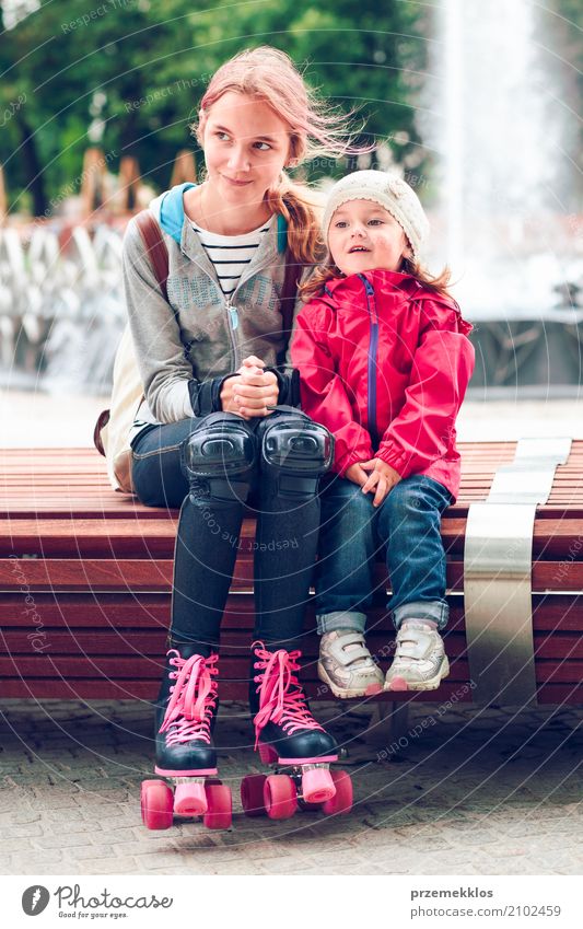 Sisters sitting on bench in a town Lifestyle Child Toddler Girl Family & Relations 2 Human being 1 - 3 years 13 - 18 years Youth (Young adults) Small Town