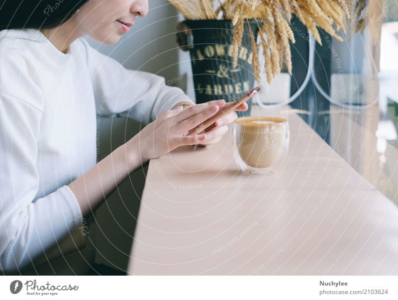 Young woman using smartphone in the cafe Beverage Coffee Lifestyle Style Happy Relaxation Leisure and hobbies Telephone Cellphone PDA Technology Internet Woman