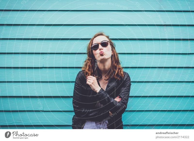 Young woman with kissing mouth and sunglasses in front of turquoise wooden facade Vacation & Travel Tourism Trip Freedom Sightseeing City trip Feminine