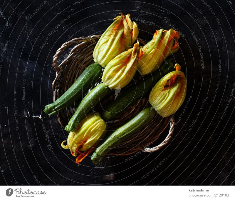 Zucchini with flowers on a dark background top view Food Vegetable Nutrition Vegetarian diet Table Group Flower Dark Fresh Yellow Green Harvest healthy
