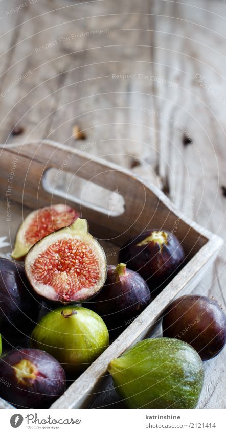Green and purple figs in a box on a wooden background Fruit Nutrition Summer Garden Dark Fresh Gray Fig food healthy Ingredients Organic Purple Raw ripe Rustic
