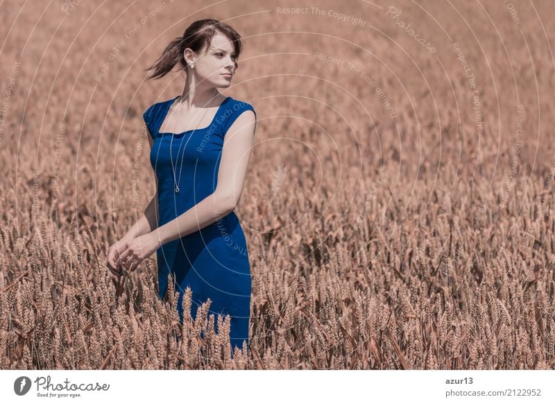Beautiful young woman with blue dress in autumn on corn field to horizon. Pretty girl with zest for life enjoying the sunshine break and life. Rest and recharge energy from time stress in environment and nature idyll.