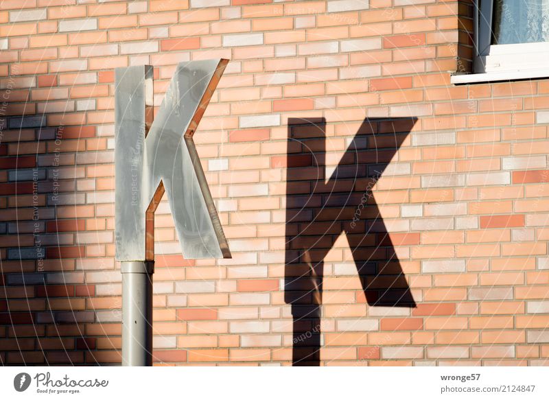 K K Wall (barrier) Wall (building) Characters Town Brown Black Silver Letters (alphabet) Light and shadow Pylon House wall Exterior shot Detail Deserted Day
