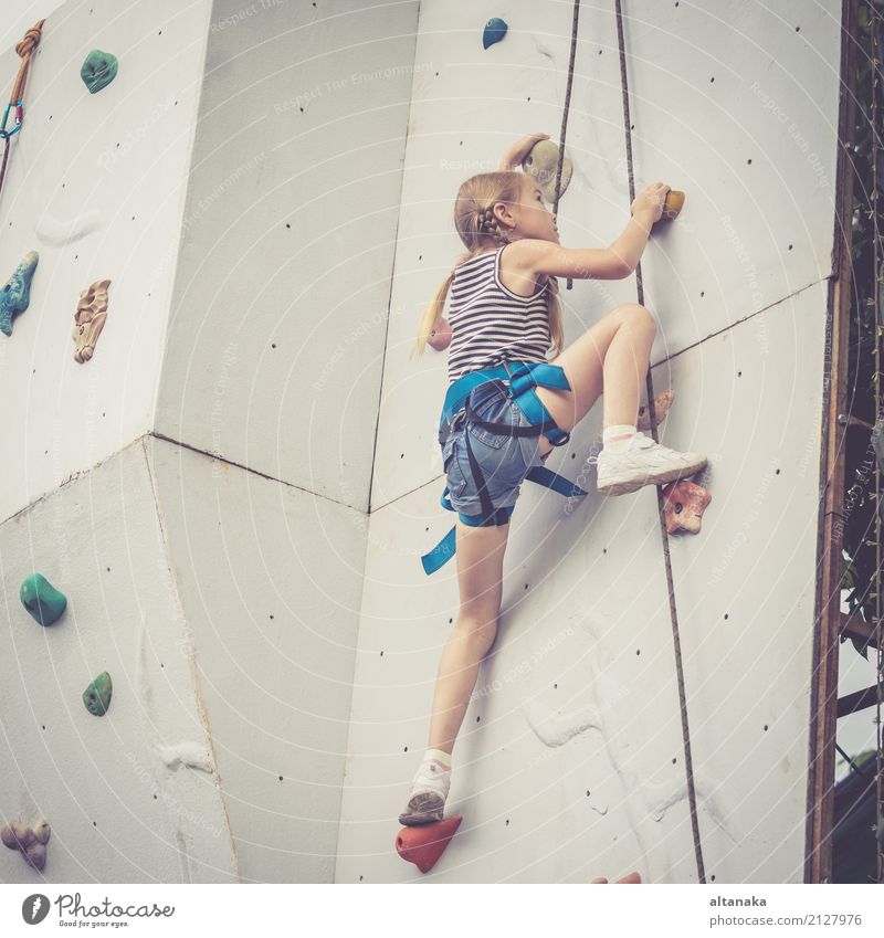 little girl climbing a rock wall outdoor. Concept of sport life. Joy Leisure and hobbies Playing Vacation & Travel Adventure Camping Entertainment Sports