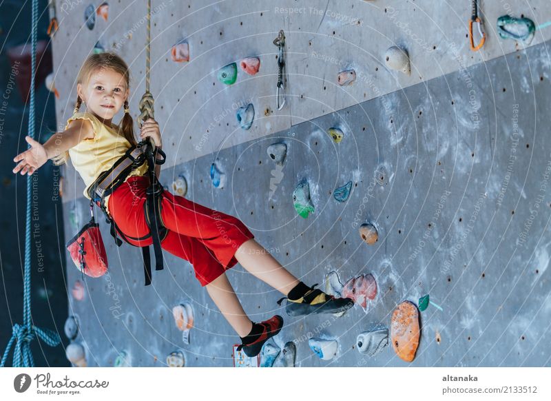 little girl climbing a rock wall indoor. Concept of sport life. Joy Leisure and hobbies Playing Vacation & Travel Adventure Camping Entertainment Sports