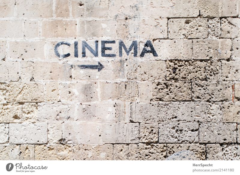 Movies to the right Wall (barrier) Wall (building) Stone Signage Warning sign Arrow Old Esthetic Brown Cinema Film industry Movie hall hint arrow Stone wall