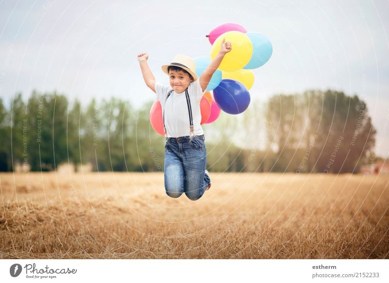 Boy jumping with balloons in the field Lifestyle Joy Vacation & Travel Adventure Freedom Summer vacation Child Toddler Infancy 3 - 8 years Meadow Field To enjoy