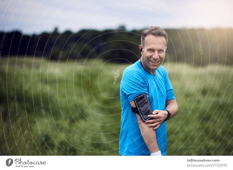 Man with smartphone on his arm standing in meadow Face Summer Sports PDA Technology Adults Arm 1 Human being 30 - 45 years Landscape Forest Beard Listening