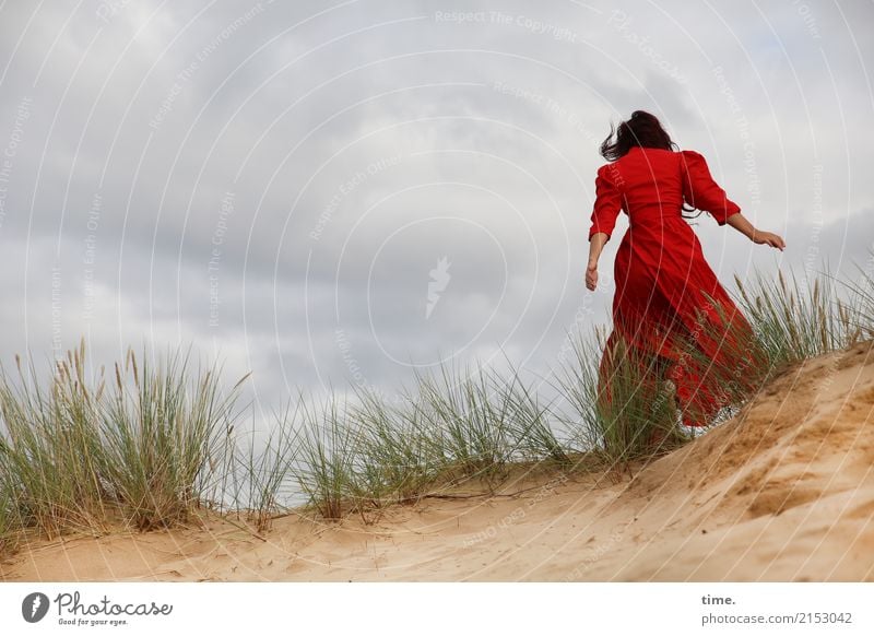 Woman in a red dress on a dune Feminine Adults 1 Human being Sand Clouds Storm clouds Wind Gale duene Marram grass Dress Brunette Long-haired Movement Walking