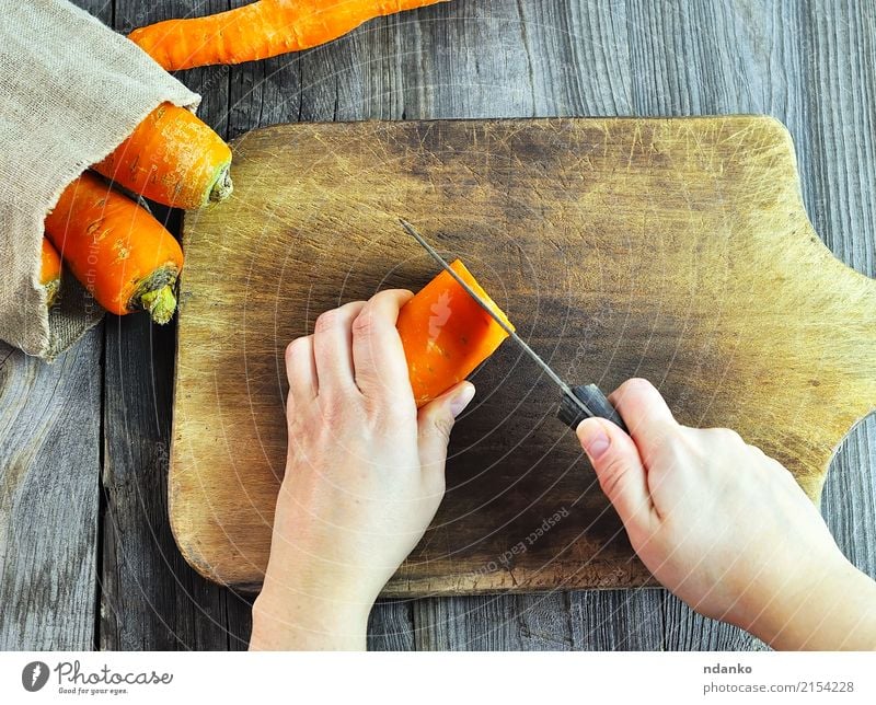 Two female hands with a knife Food Vegetable Eating Knives Body Kitchen Woman Adults Hand Fresh Gray Carrot orange part board cooking slicing Harvest health Raw