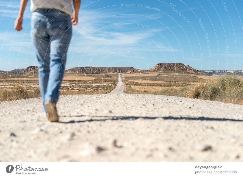 Woman walking on dirt road Relaxation Mountain Hiking Adults Nature Landscape Earth Sky Park Hill Rock Street Jeans Blue Red movie Western sierra desert Valley