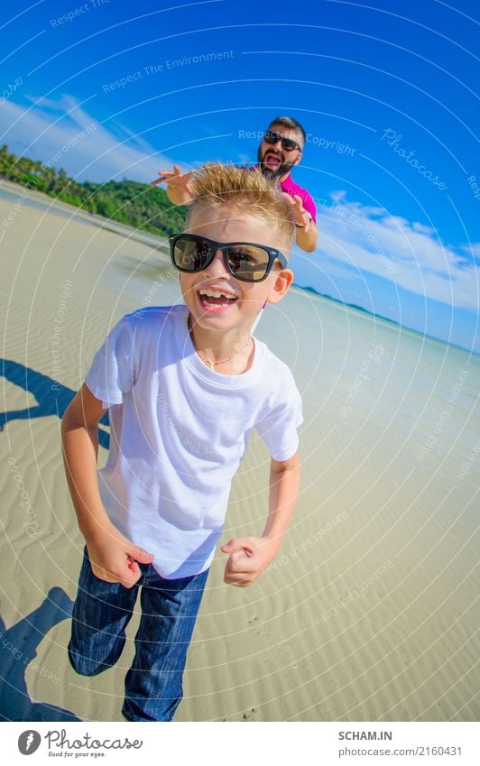 The happiest childhood: father and son running along the tropical beach. Both in casual clothing and sunglasses Joy Summer Island Masculine Boy (child) Man