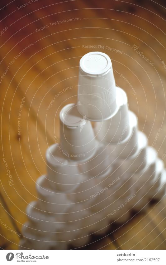 Plastic cup (stacked) Stack Mount up Balance babel Mug Ground Floor covering Wooden floor Patient Dexterity Precarious Pyramid Playing Toys Drinking Tower