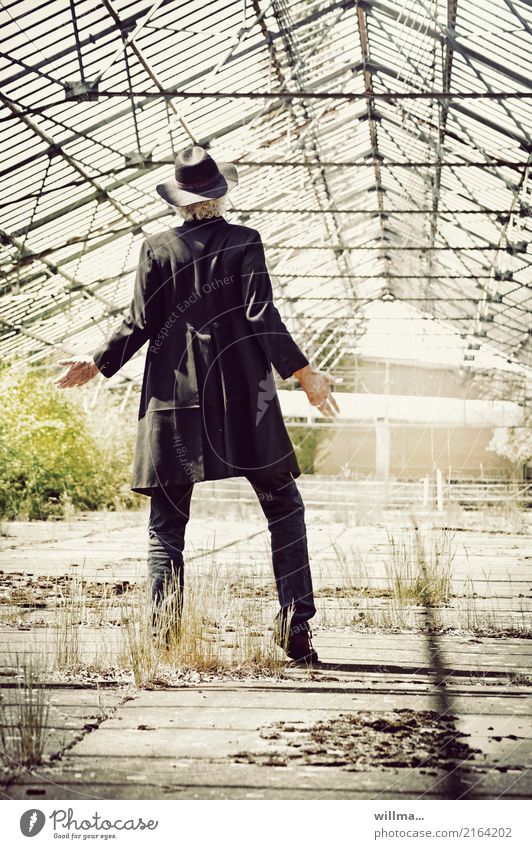 What does the world cost - Man with frock coat and floppy hat standing in an old greenhouse Frock coat Black Lifestyle Greenhouse 1 Human being Jeans Hat