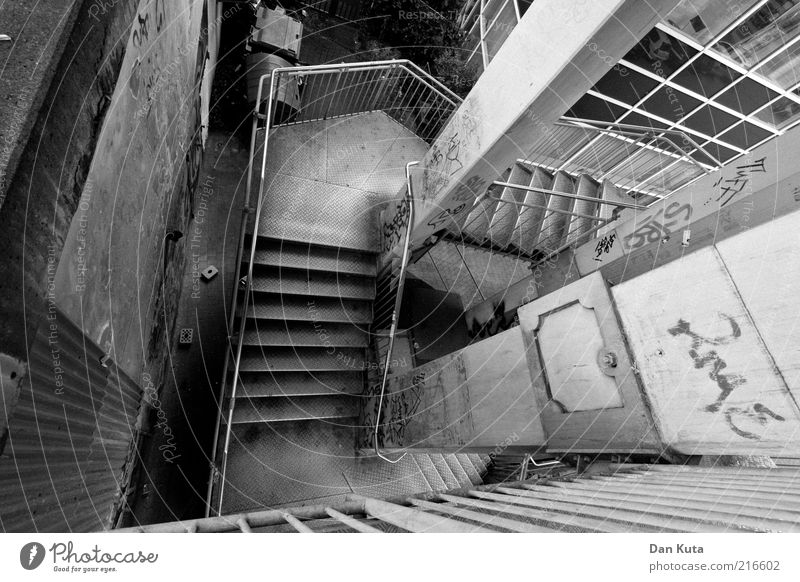 Backstreet Deserted Manmade structures Stairs Stair tower Handrail Banister Authentic Downward Story Dirty Concrete Column Graffiti Daub Black & white photo