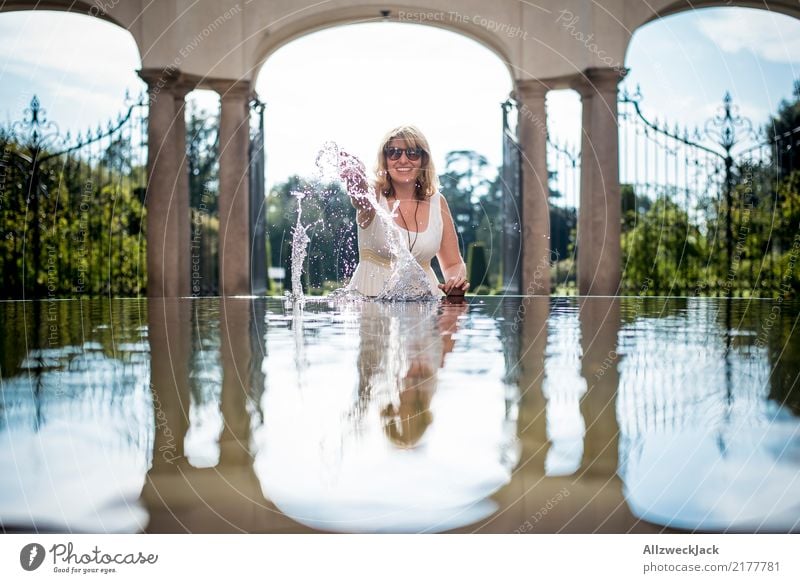 Woman with sunglasses plays with water Day Reflection Summer Joy Comical House (Residential Structure) Feminine Young woman Water Well Water basin Building