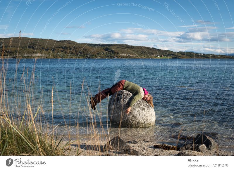 Young woman lies funny on a stone in the sea, fjord Relaxation Youth (Young adults) Nature Beautiful weather Grass Rock Coast Ocean Lofotes Stone Lie Sleep