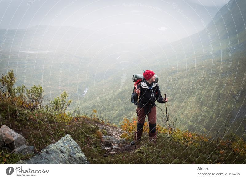 Young woman with hiking backpack stands on the edge of rain covered valley explorers Hiking Rain Valley Haze Shroud of fog Misty atmosphere Autumn Rainy weather